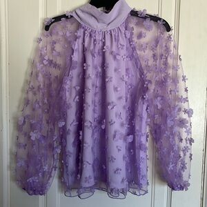 Sheer long sleeve lspeak now top” in floral lavender.
